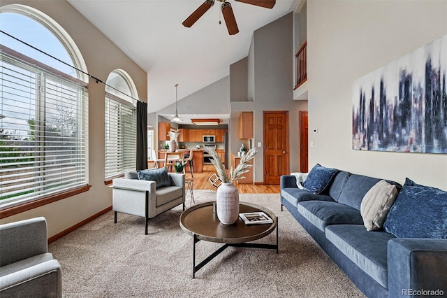 9515 Dolton Way, Highlands Ranch, CO 80126 - living room featuring ceiling fan, high vaulted ceiling, baseboards, and light colored carpet