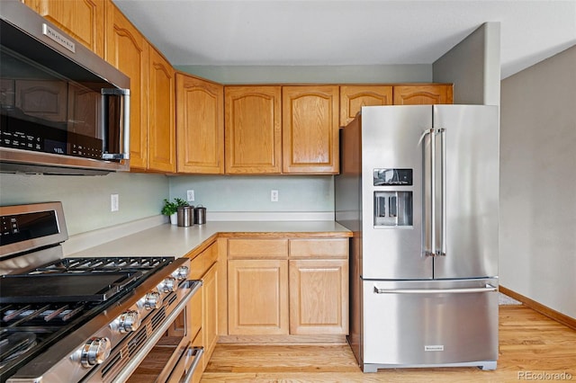 9515 Dolton Way, Highlands Ranch, CO 80126 - kitchen with stainless steel appliances, light countertops, light wood finished floors, and baseboards