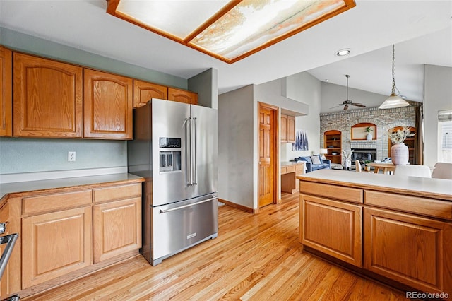 9515 Dolton Way, Highlands Ranch, CO 80126 - kitchen featuring high end fridge, ceiling fan, lofted ceiling, a fireplace, and light wood finished floors