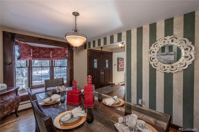 dining space featuring a baseboard heating unit and hardwood / wood-style flooring