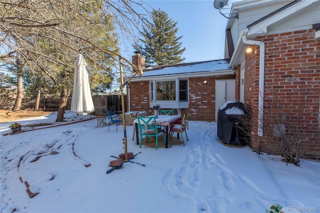 snow covered patio with a grill