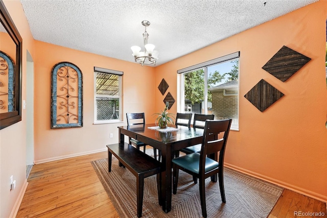 1332 Ash St, Denver, CO 80220 - dining area featuring a chandelier, light wood-type flooring, and a textured ceiling