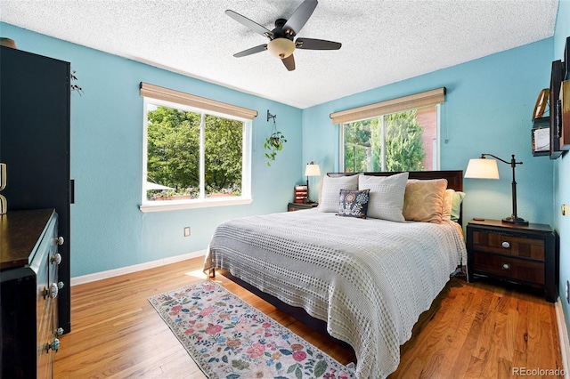 1332 Ash St, Denver, CO 80220 - bedroom with multiple windows, a textured ceiling, wood finished floors, and ceiling fan