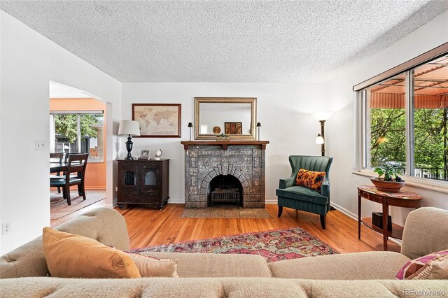 1332 Ash St, Denver, CO 80220 - living area with wood finished floors, a textured ceiling, healthy amount of natural light, and a fireplace