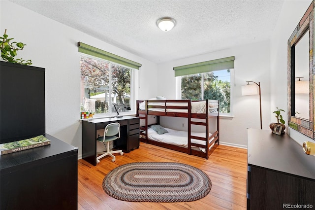 1332 Ash St, Denver, CO 80220 - bedroom featuring wood finished floors, a textured ceiling, and an office area