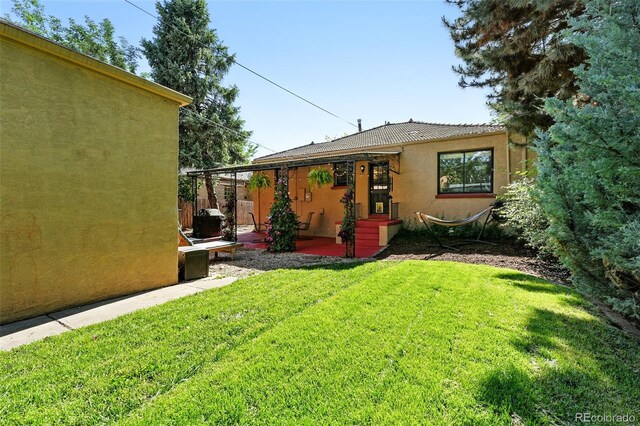 1332 Ash St, Denver, CO 80220 - back of property featuring stucco siding, a yard, and a patio area
