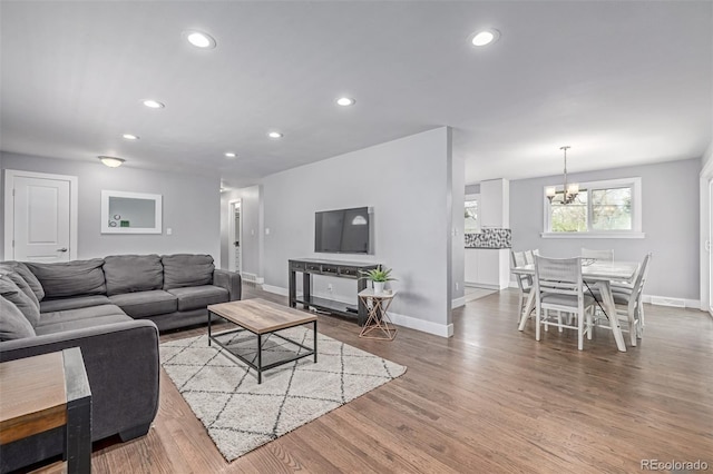 living area with baseboards, a chandelier, recessed lighting, and wood finished floors