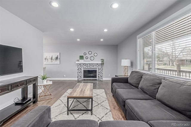 living area with recessed lighting, wood finished floors, baseboards, and a fireplace
