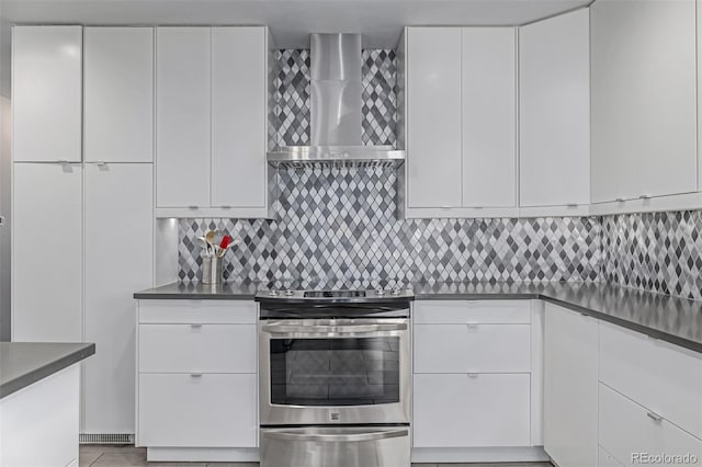 kitchen featuring electric stove, wall chimney range hood, and modern cabinets