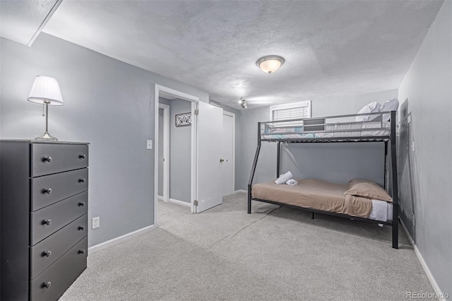 carpeted bedroom featuring a textured ceiling and baseboards