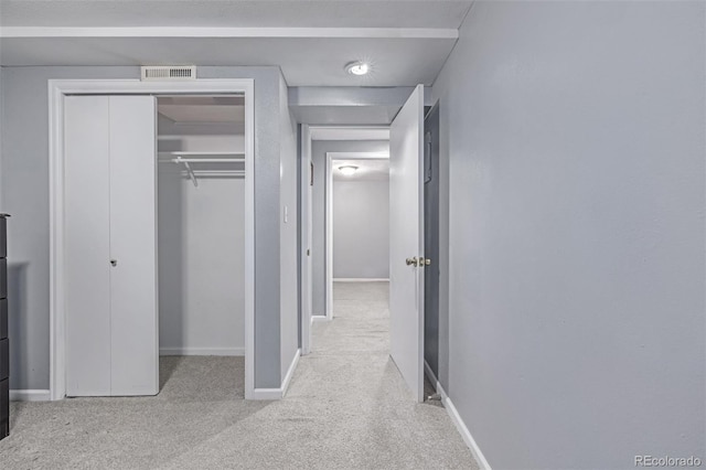 unfurnished bedroom featuring baseboards, carpet floors, and a closet
