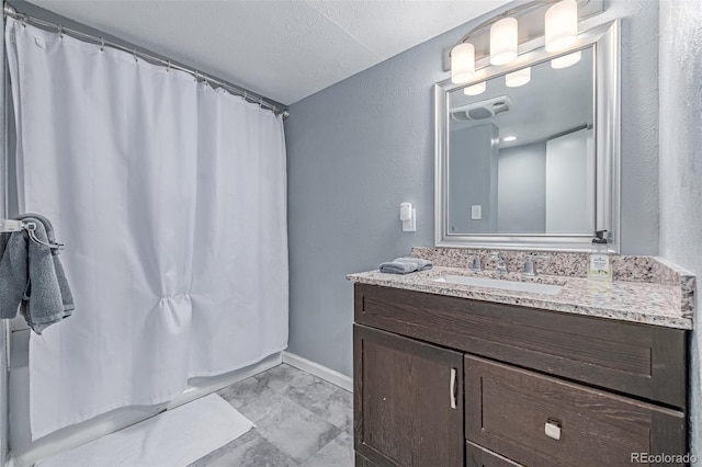 full bathroom featuring marble finish floors, vanity, baseboards, and shower / tub combo