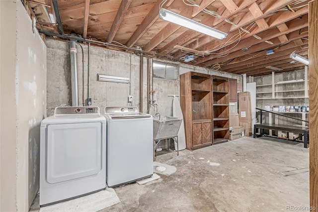 unfinished basement featuring independent washer and dryer and a sink