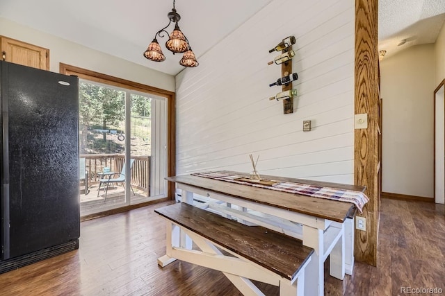 dining area with wooden walls and wood finished floors