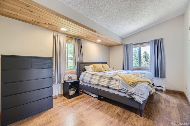 bedroom featuring lofted ceiling, multiple windows, and wood finished floors