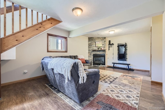 living area with a textured ceiling, baseboards, and wood finished floors