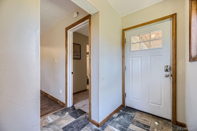 entryway with stone finish flooring and baseboards