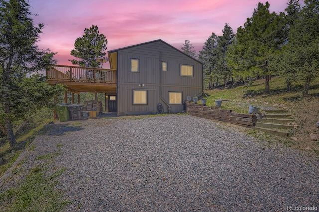 back house at dusk featuring a wooden deck