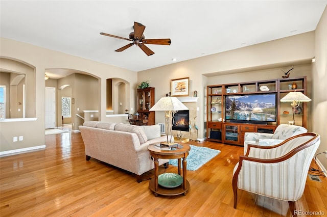 living room with ceiling fan and light hardwood / wood-style flooring