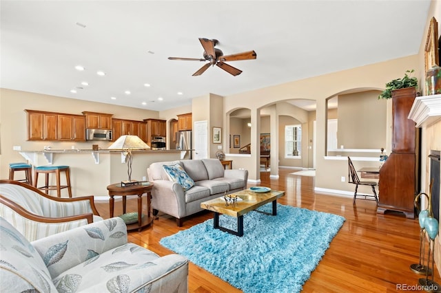 living room featuring light wood-type flooring and ceiling fan