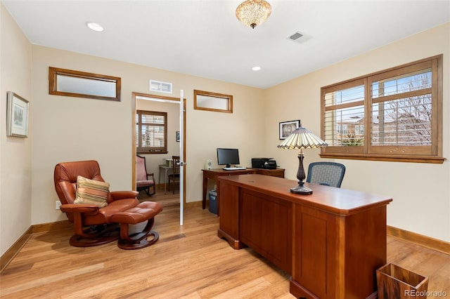 office area with a wealth of natural light and light hardwood / wood-style flooring