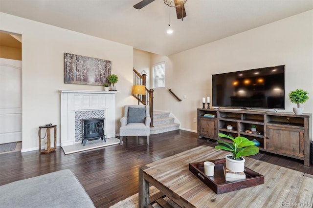 living room with hardwood / wood-style flooring, a wood stove, and ceiling fan