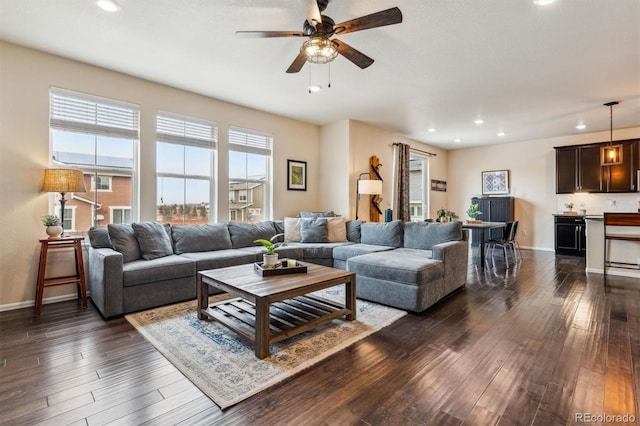 living room featuring dark wood-type flooring and ceiling fan