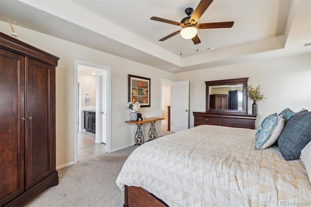 bedroom with ceiling fan, a tray ceiling, and light carpet