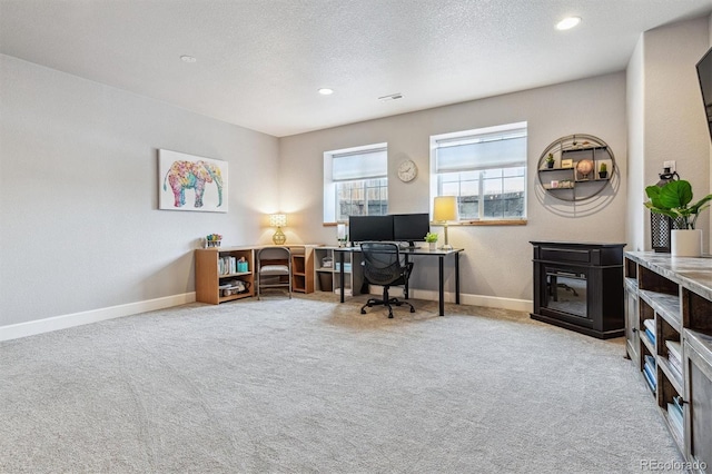 carpeted office with a textured ceiling