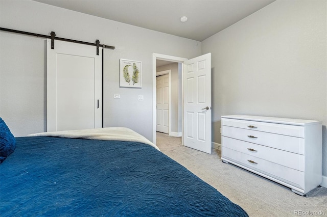 bedroom with a barn door and light colored carpet