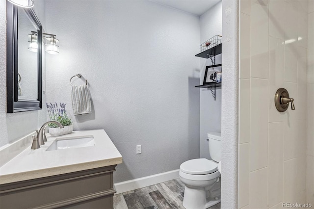 bathroom featuring vanity, hardwood / wood-style flooring, a shower, and toilet