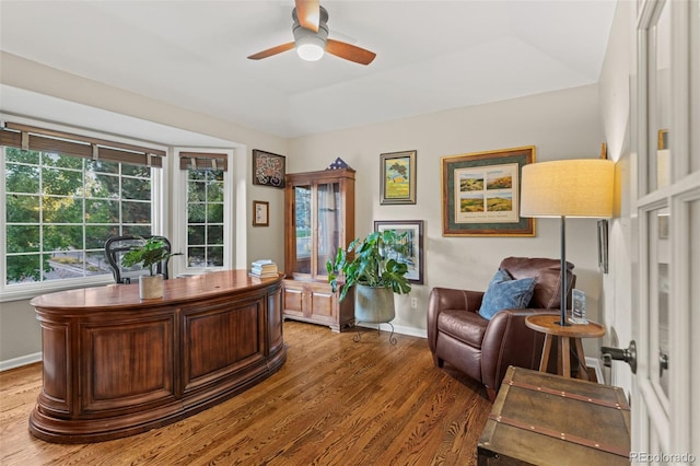 office space featuring a ceiling fan, light wood-type flooring, and baseboards