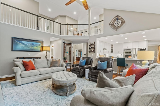 living area featuring ceiling fan, baseboards, wood finished floors, and recessed lighting