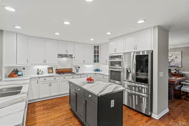 kitchen featuring stainless steel appliances, white cabinets, and under cabinet range hood