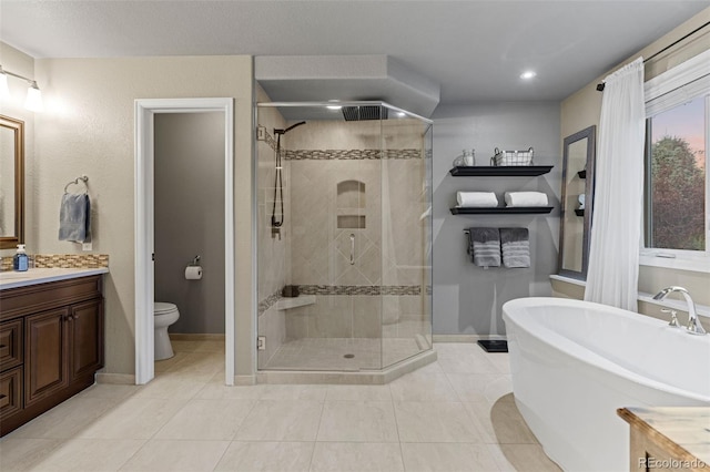 full bathroom with toilet, a soaking tub, tile patterned floors, vanity, and a shower stall