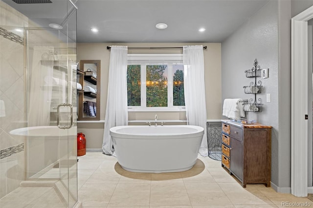 bathroom featuring a freestanding tub, a shower stall, baseboards, and recessed lighting