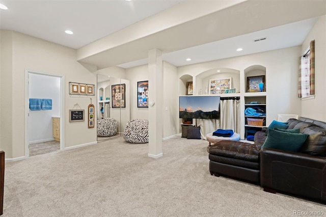 living area featuring arched walkways, recessed lighting, visible vents, carpet flooring, and baseboards