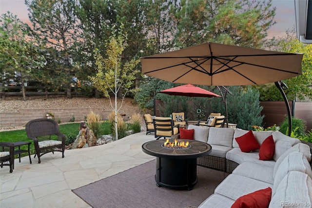 patio terrace at dusk featuring an outdoor living space with a fire pit