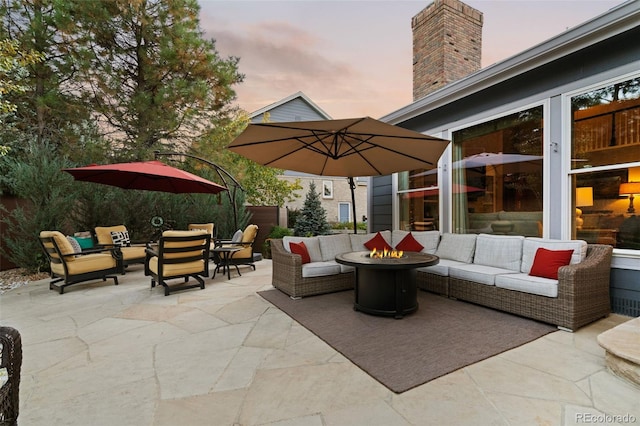 patio terrace at dusk featuring an outdoor living space with a fire pit