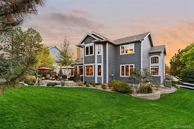 rear view of property featuring a yard, a gazebo, a patio area, central AC, and fence