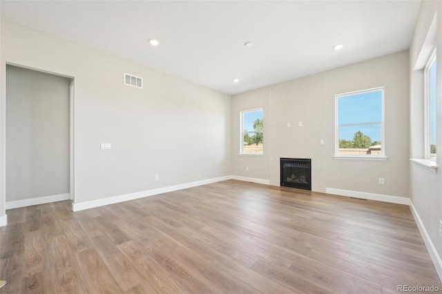 unfurnished living room featuring a fireplace and light hardwood / wood-style flooring