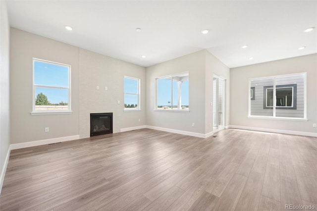 unfurnished living room with light hardwood / wood-style flooring and a fireplace