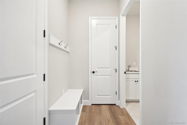 mudroom with sink and light hardwood / wood-style floors