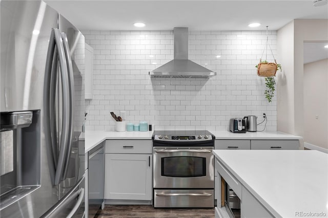 8060 Stuart Pl, Westminster, CO 80031 - kitchen with appliances with stainless steel finishes, wall chimney exhaust hood, decorative backsplash, light countertops, and recessed lighting
