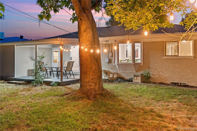 8060 Stuart Pl, Westminster, CO 80031 - back of property at dusk with a lawn, brick siding, and a shingled roof