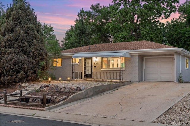 8060 Stuart Pl, Westminster, CO 80031 - single story home with a garage, concrete driveway, covered porch, and brick siding