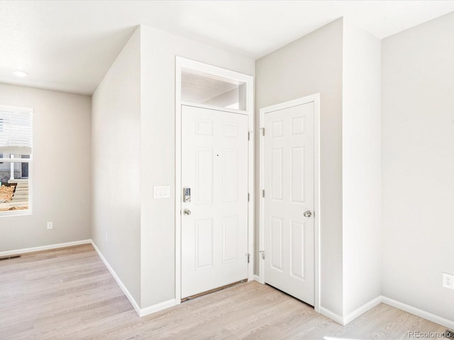 foyer entrance featuring baseboards, visible vents, and light wood-type flooring