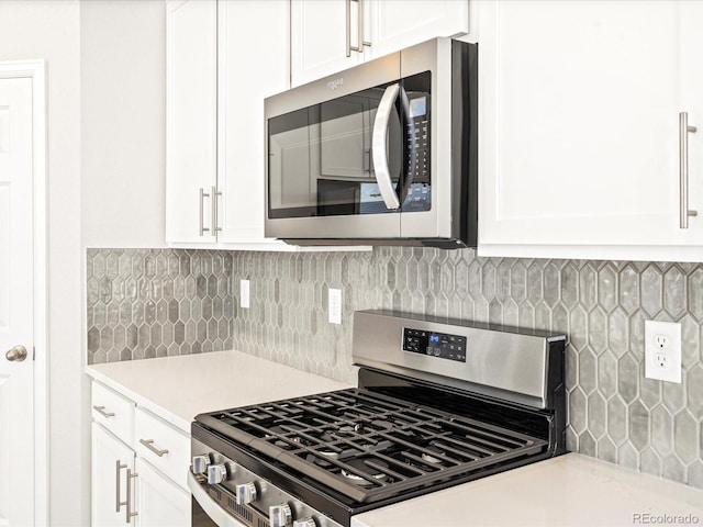 kitchen with light countertops, appliances with stainless steel finishes, white cabinets, and tasteful backsplash