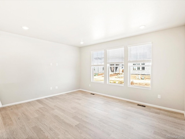 spare room with light wood-style floors, baseboards, recessed lighting, and visible vents
