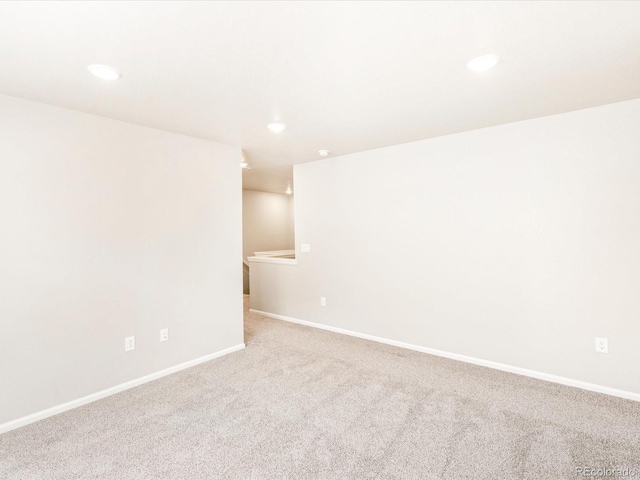 carpeted empty room featuring recessed lighting and baseboards